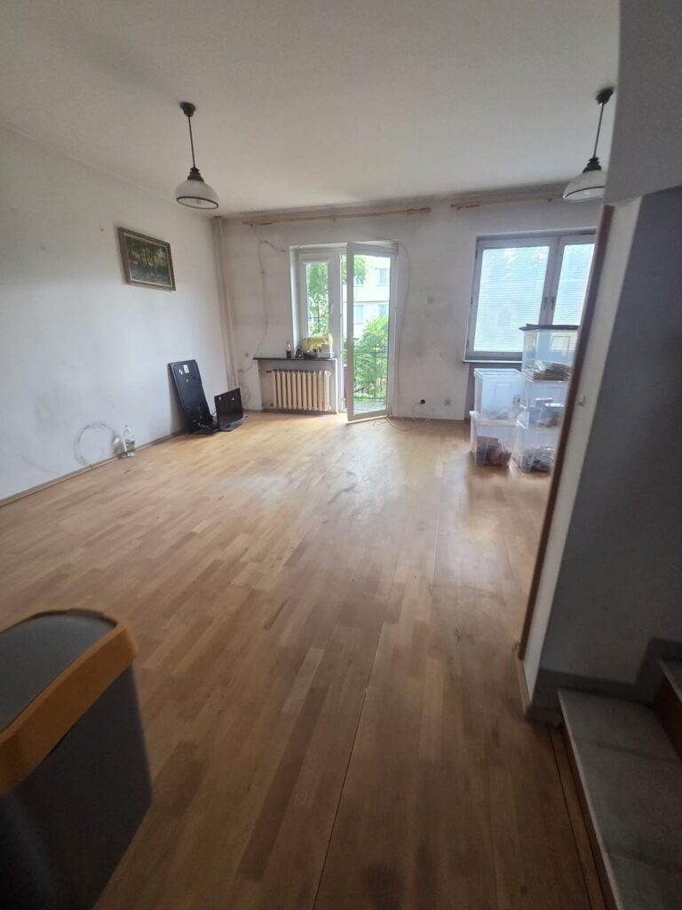 Opróżniony salon z wyjściem na taras – dom przy ul. Nefrytowej w Piasecznie
